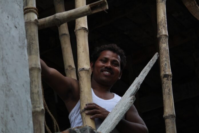 A construction worker among bamboo scaffolding on a building site