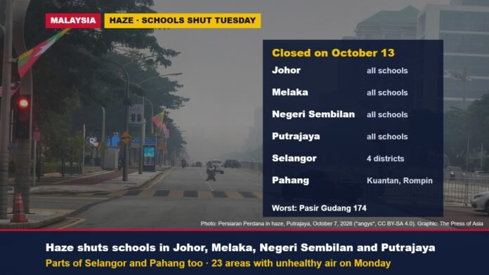 Haze over Persiaran Perdana, Putrajaya, with a list of states closing schools on October 13