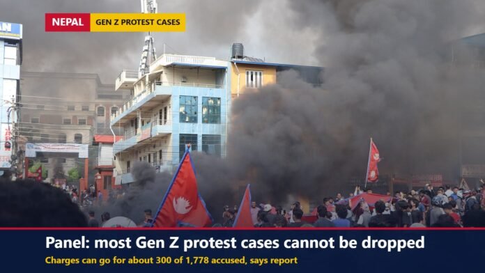 Protesters with Nepali flags in front of a building with thick smoke rising during the September 2025 Gen Z protests in Bharatpur