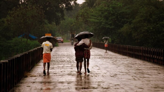 People crossing a bridge in Kerala during rain, September 2009 — archival photograph