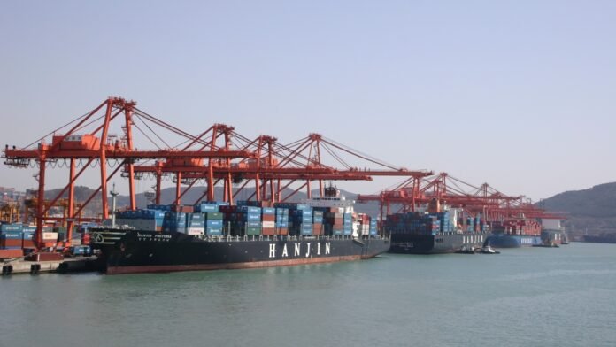 Container cranes and ships at Busan port — archival photograph, not the 2026 expo