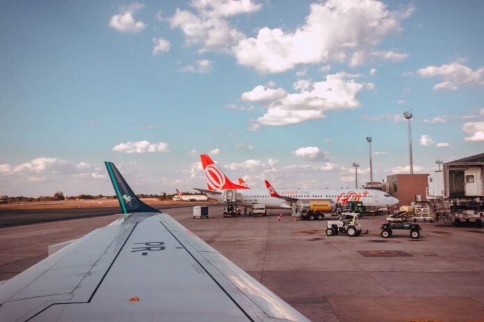 pexels-photo-1381423-1381423 View of airplanes at an airport tarmac, parked under a clear blue sky with clouds.