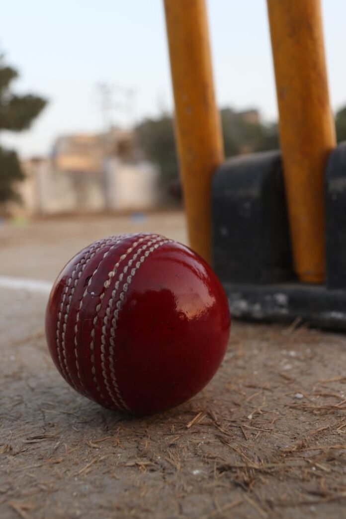 pexels-photo-20652472-20652472 Red cricket ball with stumps in the background; representative cricket photograph.
