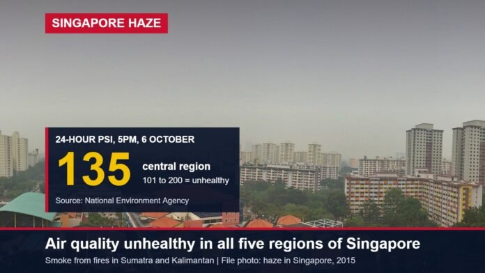Hazy view of Singapore housing blocks with a box showing a 24-hour PSI of 135 in the central region