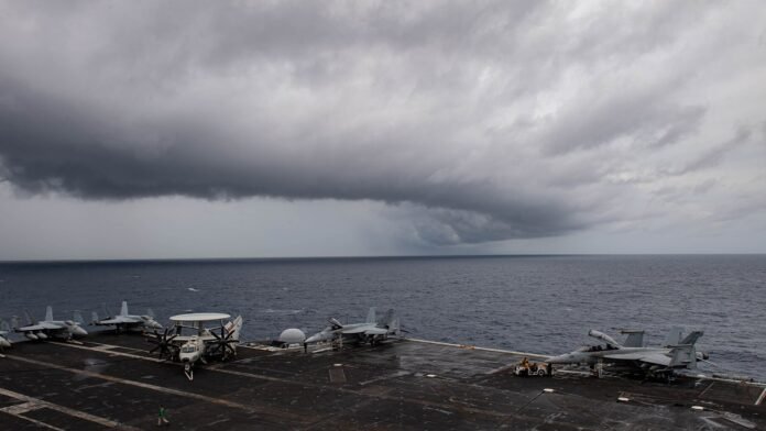 USS Theodore Roosevelt in the Indian Ocean, September 2024 Aircraft on the flight deck of the aircraft carrier USS Theodore Roosevelt under storm clouds